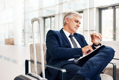 Young man looking at camera while sitting on seat