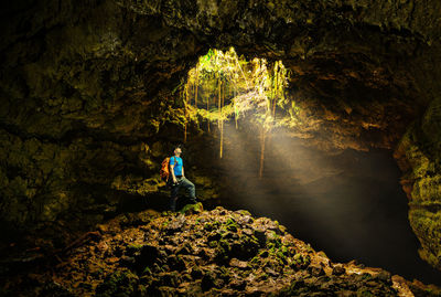 Man standing on rock in cave