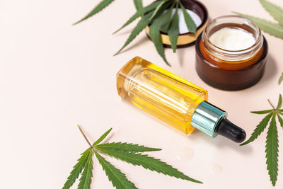 Herbal alternative medicine concept. cannabis cosmetic cream, face serum and hemp leaves