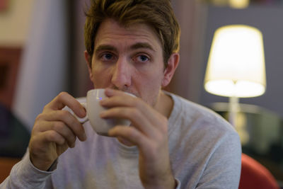 Portrait of young man drinking glass