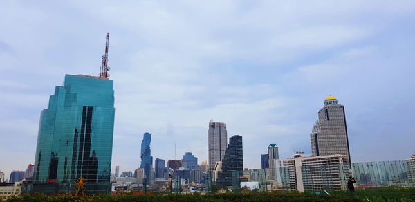 Low angle view of buildings against cloudy sky