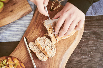 Close-up of women cutting bread