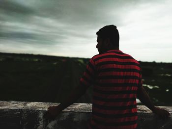 Rear view of man standing against sky