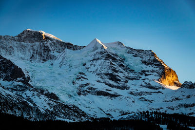 Scenic view of snowcapped mountains against clear blue sky