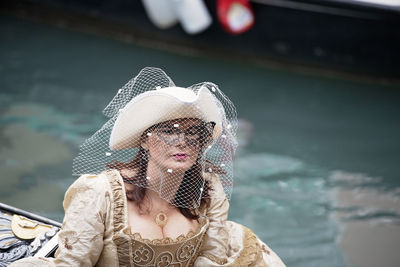 Portrait of woman wearing hat against sea