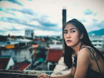 Portrait of beautiful young woman in city