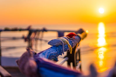 Close-up of people in boat at sea during sunset
