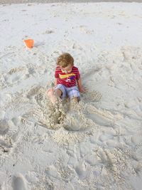 High angle view of girl playing on sand at beach