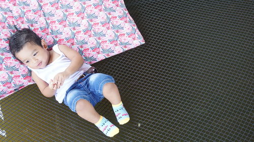 High angle view of cute baby boy lying on cot