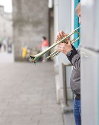 Man holding umbrella while standing on street in city