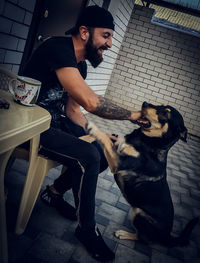 Young man and dog sitting on floor