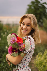 A teenage girl walks with a bouquet of flowers in a floristic flower farm.