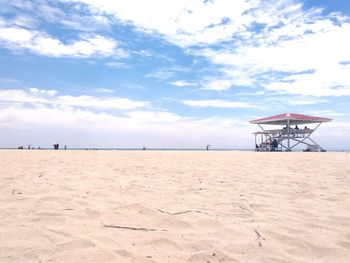 Scenic view of beach against cloudy sky