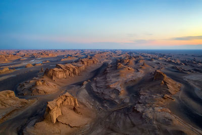 Scenic view of desert against sky during sunset