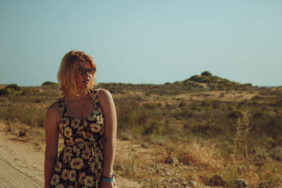 Woman standing on field against clear sky