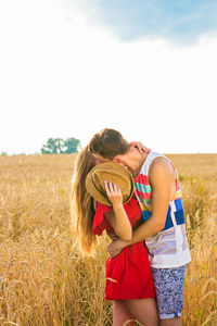 Full length of young woman standing in farm against sky