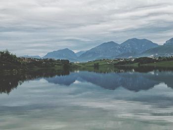 Scenic view of lake by mountains against sky