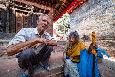 Rear view of people sitting on walkway