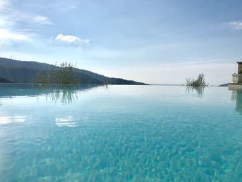 Scenic view of swimming pool by sea against sky