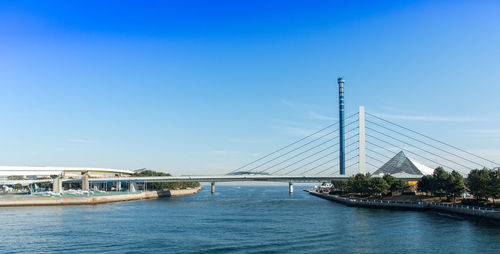 View of bridge over river against clear blue sky