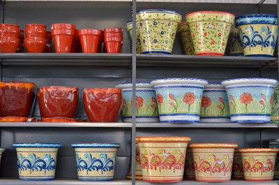 Various pots arranged on shelves for sale in store