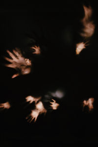 Defocused image of illuminated lights against sky at night