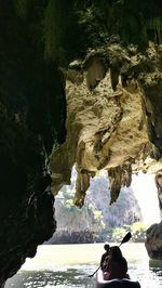 Woman standing on rock by sea
