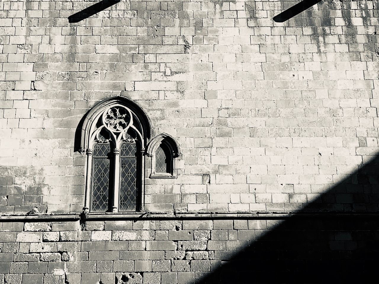 LOW ANGLE VIEW OF BRICK WALL WITH BUILDING