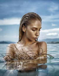 Close-up of young woman against sea