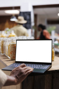 Midsection of woman using laptop at office