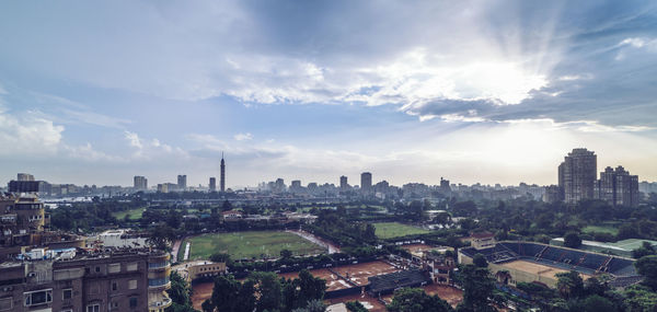 View of cityscape against cloudy sky