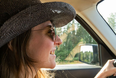 Close-up of smiling woman driving car