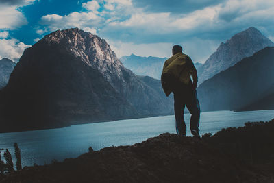 Rear view of man looking at mountain against sky