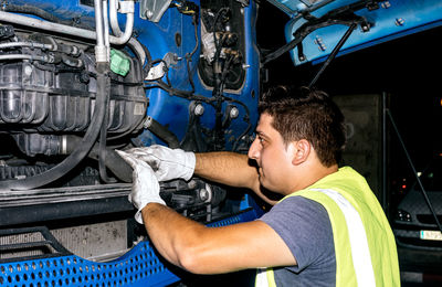 Worker checking his truck engine