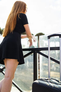 Young female tourist leaning on railing