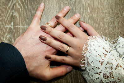 Close-up of couple holding hands on table