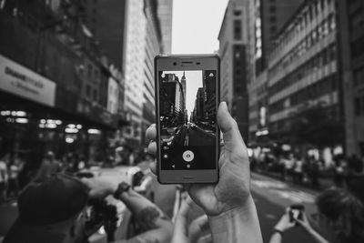 Mobile phone against modern buildings in city