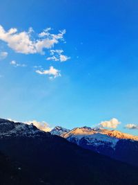 Scenic view of snowcapped mountains against blue sky