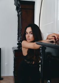 Portrait of young woman sitting on floor at home