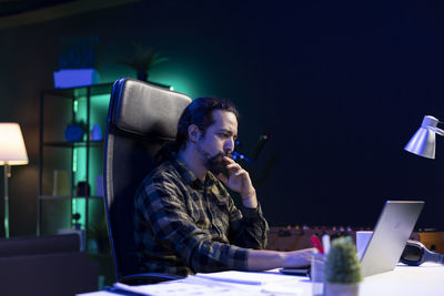 Man using mobile phone while sitting on table