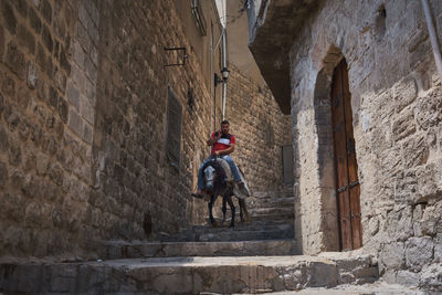 Rear view of man standing against wall