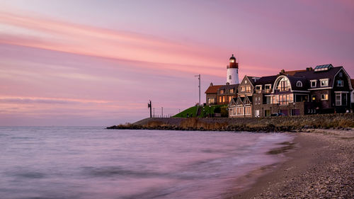 View of sea against buildings during sunset