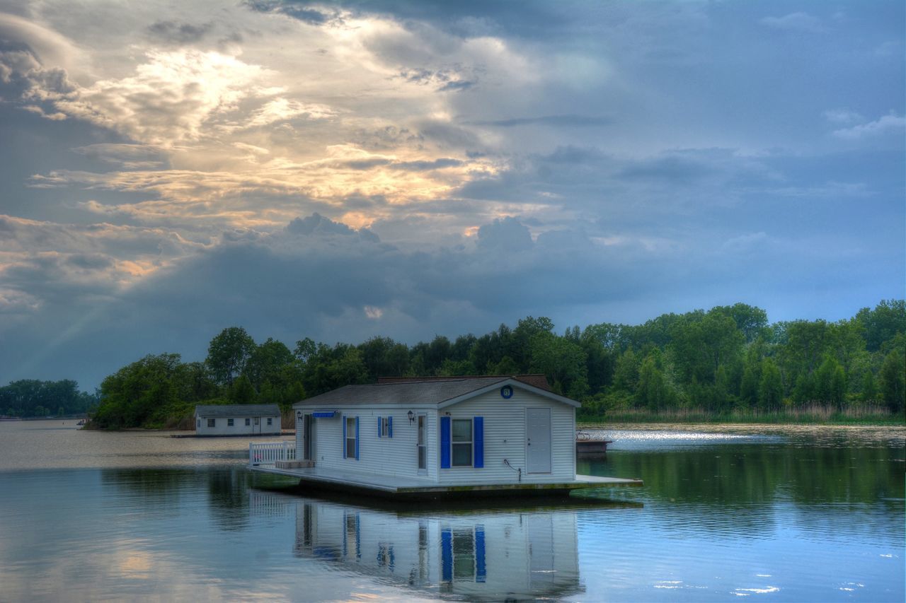 water, sky, building exterior, architecture, built structure, tree, waterfront, cloud - sky, lake, reflection, house, cloud, tranquil scene, tranquility, cloudy, scenics, nature, river, beauty in nature, outdoors