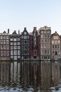 Reflection of building in river against clear sky