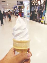 Man holding ice cream cone on sidewalk