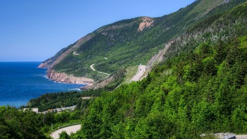 Scenic view of sea and mountains against clear sky
