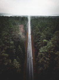 Aerial view of road in forest against sky