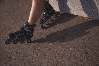 Low section of man rollerskating on road