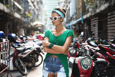 Portrait of young woman standing in city