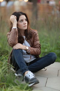 Full length of young woman sitting outdoors